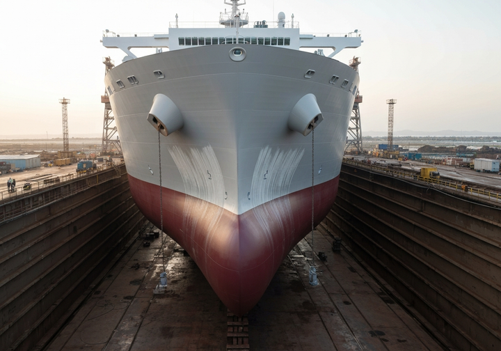 Industrial vessel hull in dry dock with marine immersion primer being applied